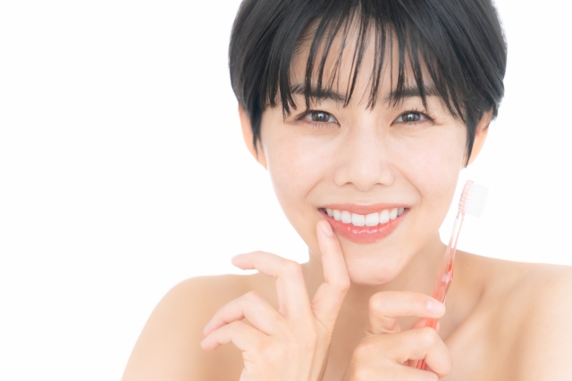 歯ブラシを持つ笑顔の女性